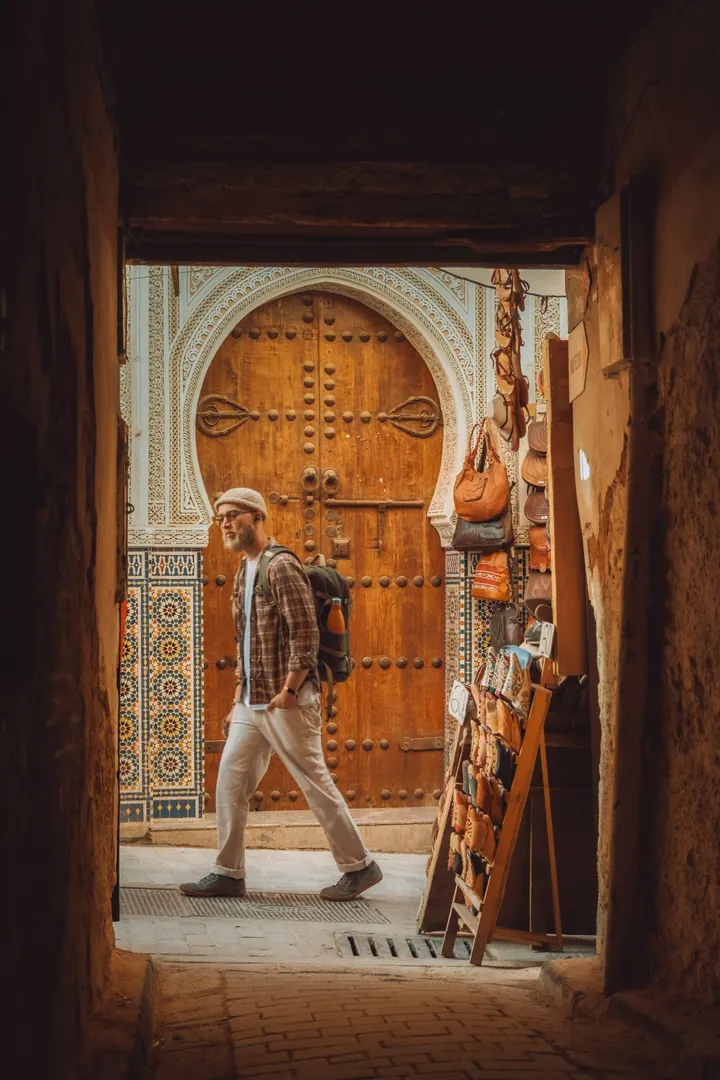 Traveller walking through a carved doorway