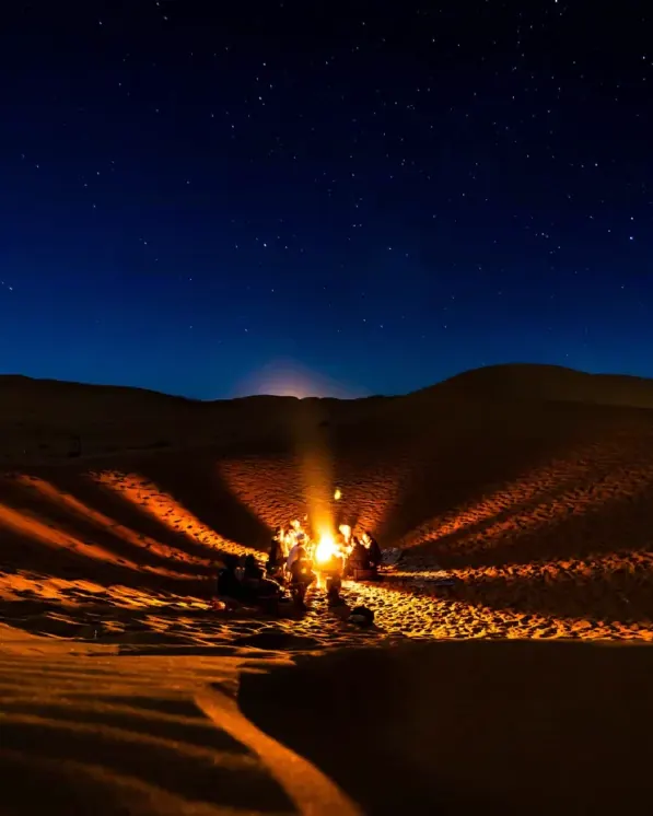 Desert camp lit up under the stars